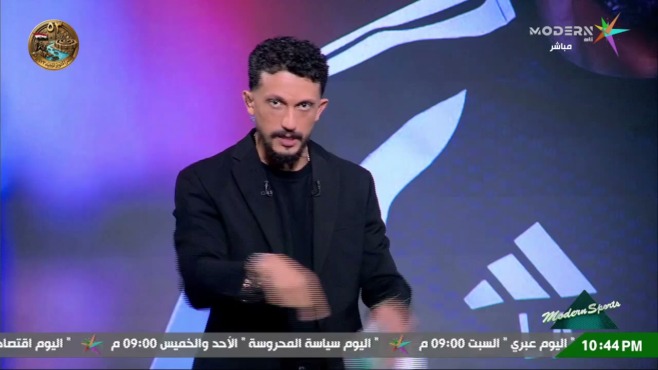 أمير هشام في استوديو مودرن سبورتس وخلفه شعار الأهلي